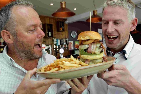 CONQUEST: Trevor Ayling, right and Karl Pinfold, managers of Quarters in Southbourne, attempt their burger eating challenge - 3218883